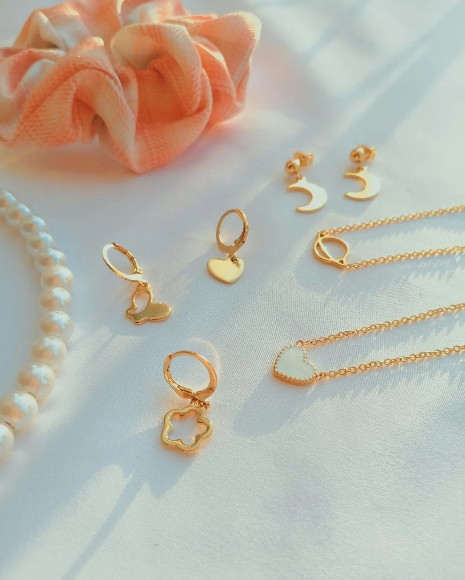 gold beaded necklace on white textile